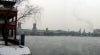 View across a river, with smokestacks and factory buildings in the background.