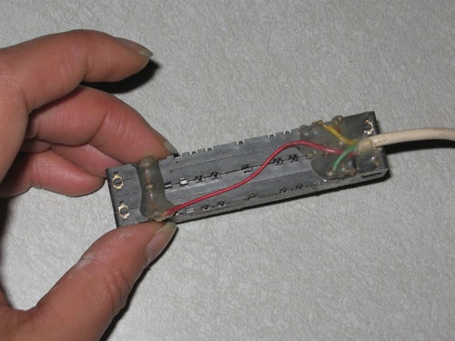 On the bottom of the potentiometer, the wire is hot-glued in place: green for ground, and yellow and red on opposite ends of the slider tracks.