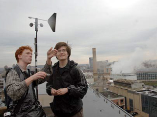 Photo of members of Team Wind with a wind turbine behind them.