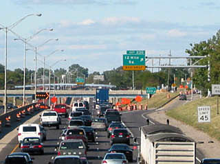 A photo of a traffic jam on a three lane highway.