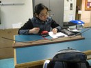 Photo of a student observing a ball rolling on a ramp with multiple hills.