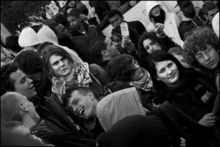 Black and white photo of a small crowd of high school age boys and girls talking and laughing among themselves.