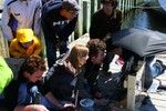 Several people laughing at the monitors and laptop.