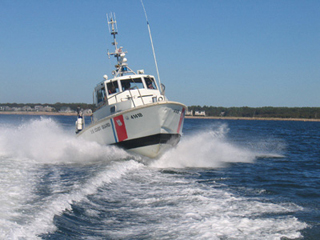 Front view of small powerboat creating waves.