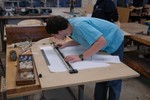 A student lays out grid lines for his lines plan.