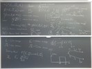 Neutron transport related equations on two blackboards.