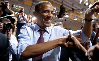 In a crowd, President Obama shakes hands.