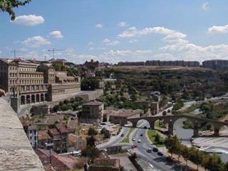 Photo of a city overlooking a highway and a river.